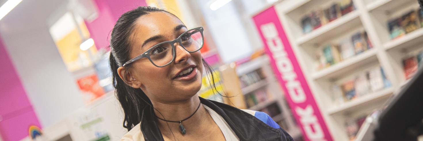 Girl with a library card at the library