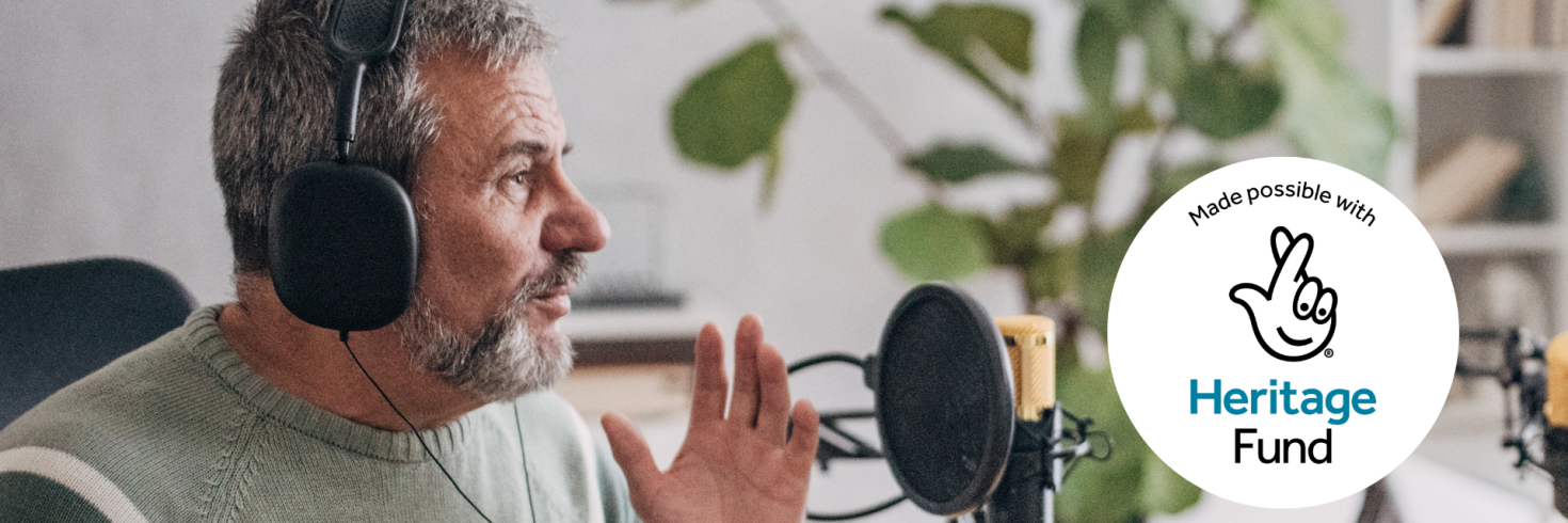 older man talking into a microphone and heritage lottery logo