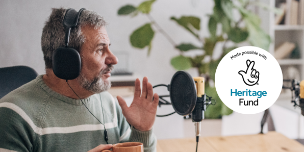 Older man talking into a microphone and heritage lottery funding logo